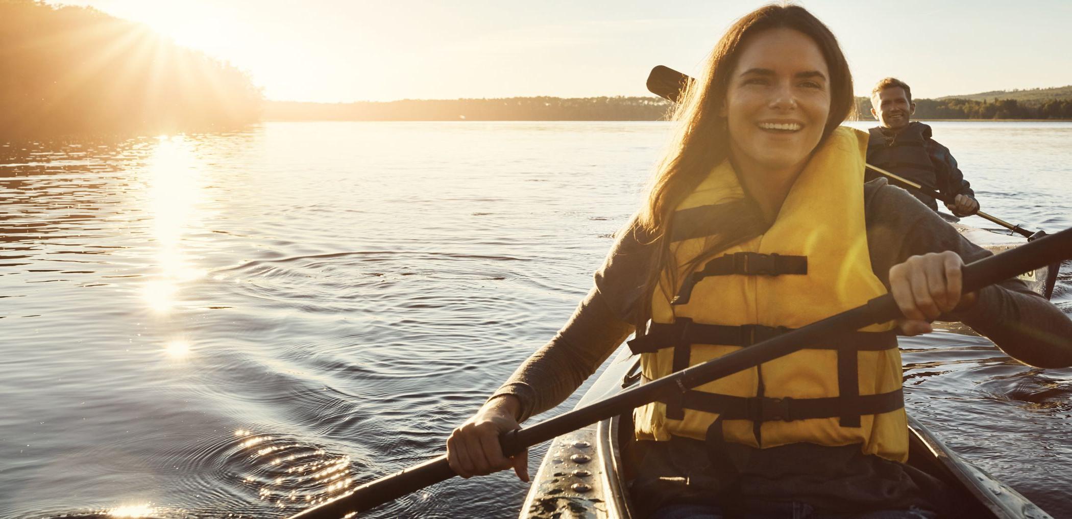 Smiling Patelco customers kayak on the Bay at sunset.